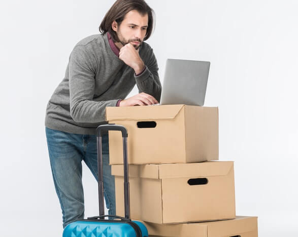 Explaining hosting with the photo of A man using a laptop on top of stacked cartons.